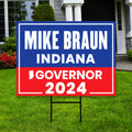 a blue and red political sign in front of a house