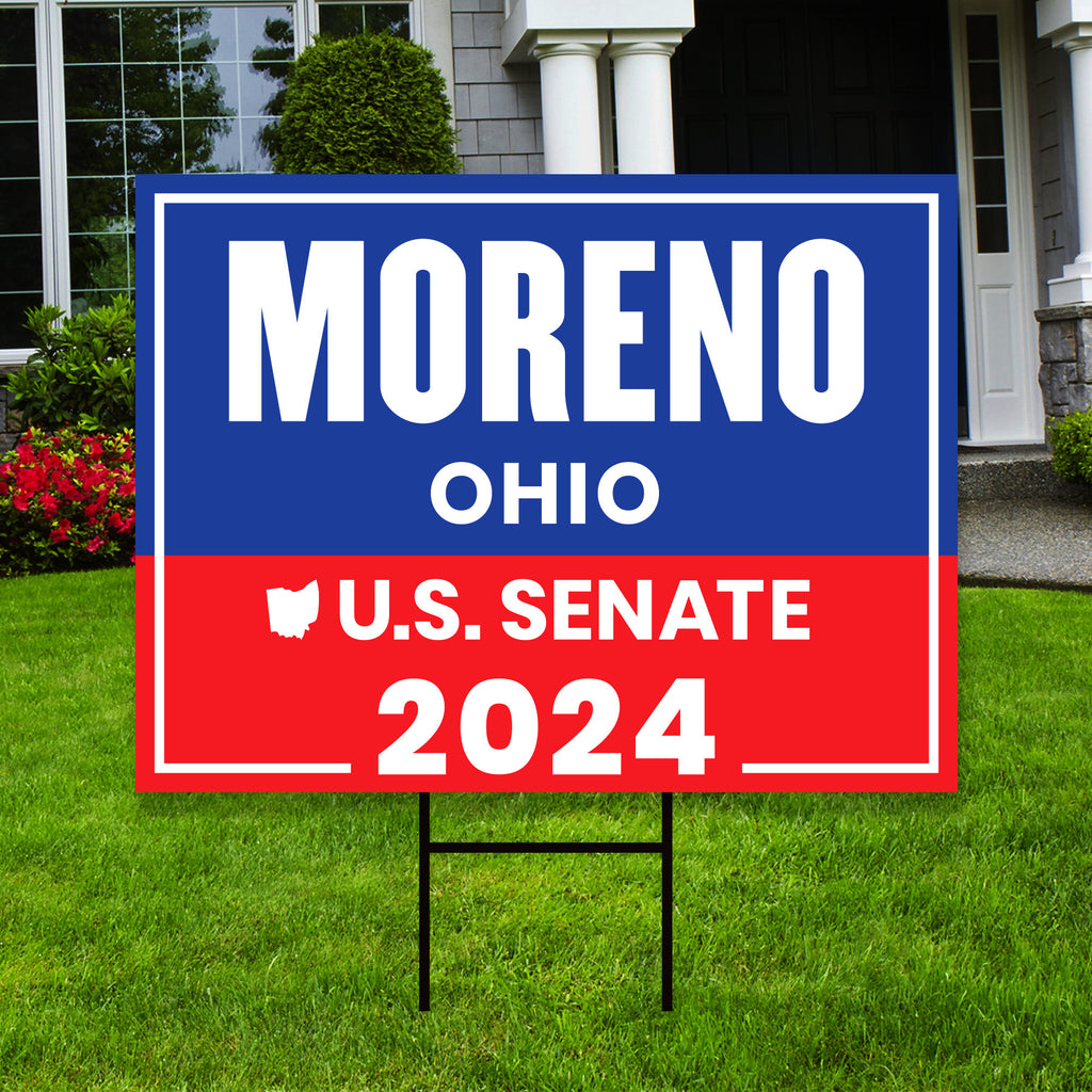 a yard sign with the name of a house in the background