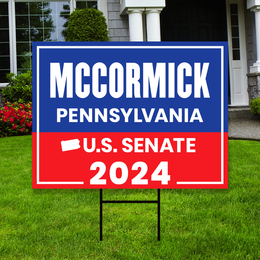 a blue and red political sign in front of a house